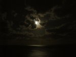 The moon was glowing through the clouds.