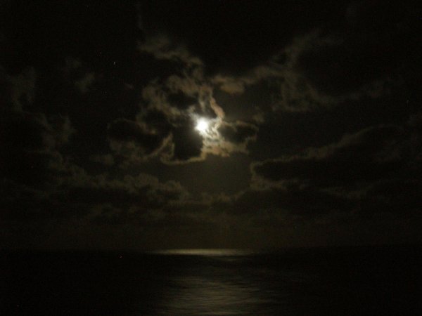 The moon was glowing through the clouds.